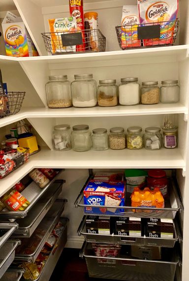 Organized pantry shelves with jars, snacks, and packaged foods.