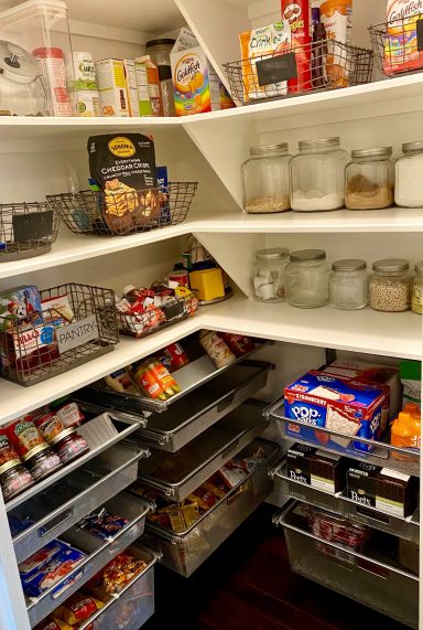 A neatly organized pantry filled with various food items and jars on multiple shelves.