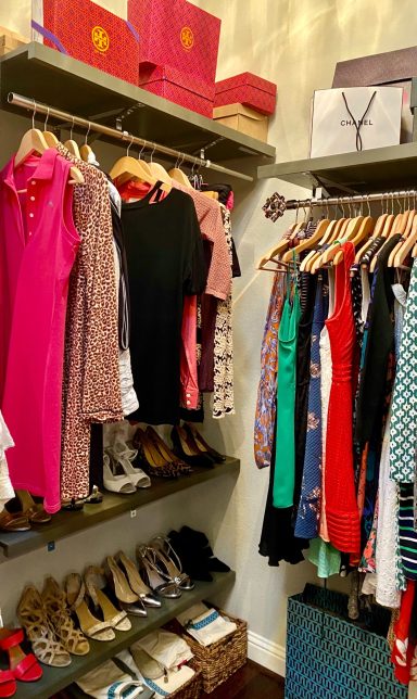 A closet with colorful dresses on hangers and shoes on shelves.