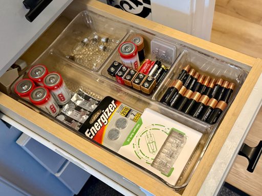 Drawer containing various batteries, battery holders, and small electronic components.