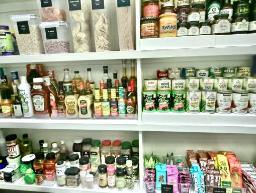 Shelves filled with various condiments, sauces, and spices in jars and bottles.
