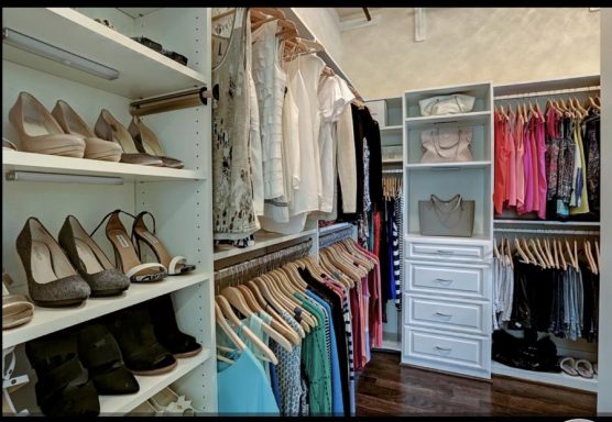 A well-organized closet featuring shoes on shelves and garments neatly hung.