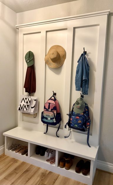 Mudroom with hooks for hats and jackets, and storage for bags and shoes below.