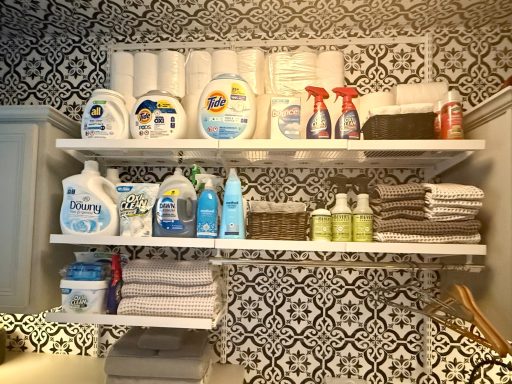 Shelves in a laundry room displaying cleaning products and neatly folded towels.