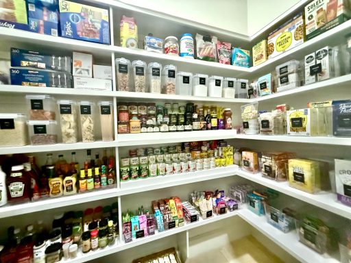Organized pantry with various food and beverage products on shelves.
