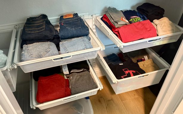 Neatly organized drawers with folded clothes in various colors and styles.